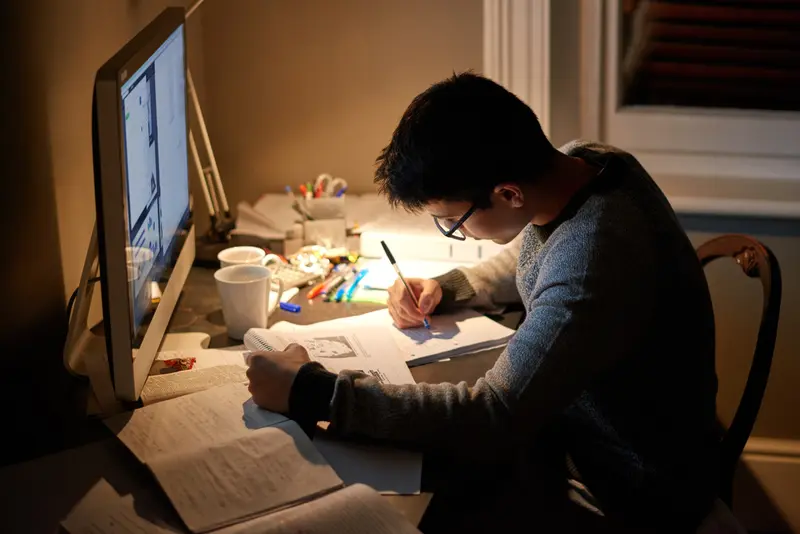 Joven dibujando y aprendiendo en su escritorio