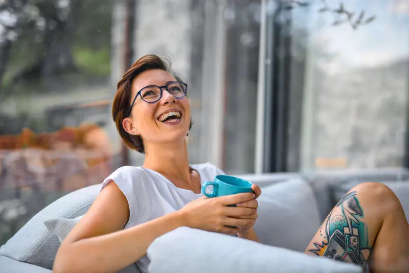 Mujer sonriendo con una taza en las manos