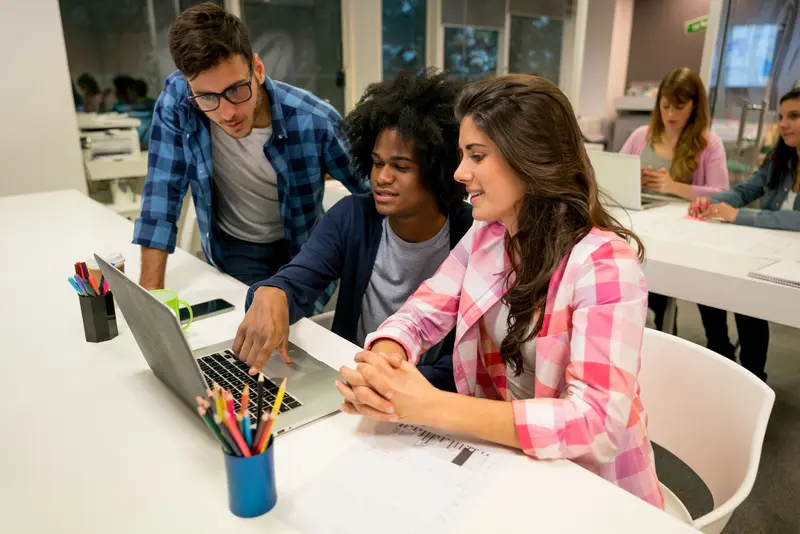 Grupo de jóvenes trabajando juntos con sus laptops